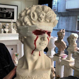A statue with a bloody bandage over its eyes.